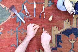 A showcase of some of our rug repair tools on an antique Persian Serapi.